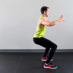 Person führt korrekte Kniebeuge für Zirkeltraining ohne Geräte aus Person führt korrekte Kniebeuge für Zirkeltraining ohne Geräte aus